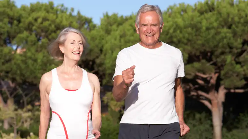 Retirees walking outdoors in sunny weather