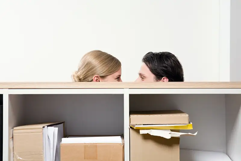 man and woman behind shelving unit