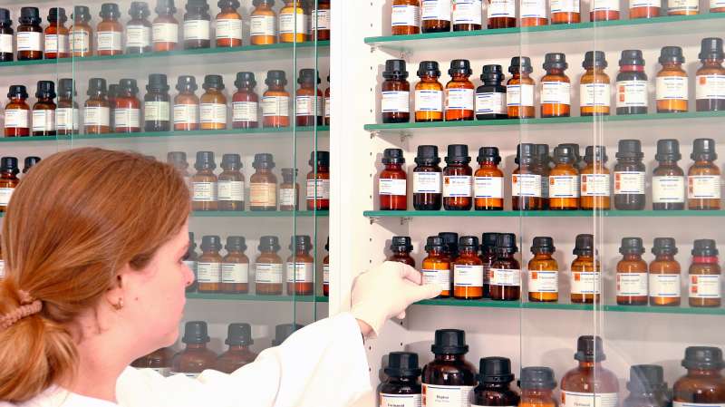 pharmacist pulling bottles off the shelves of apothecary