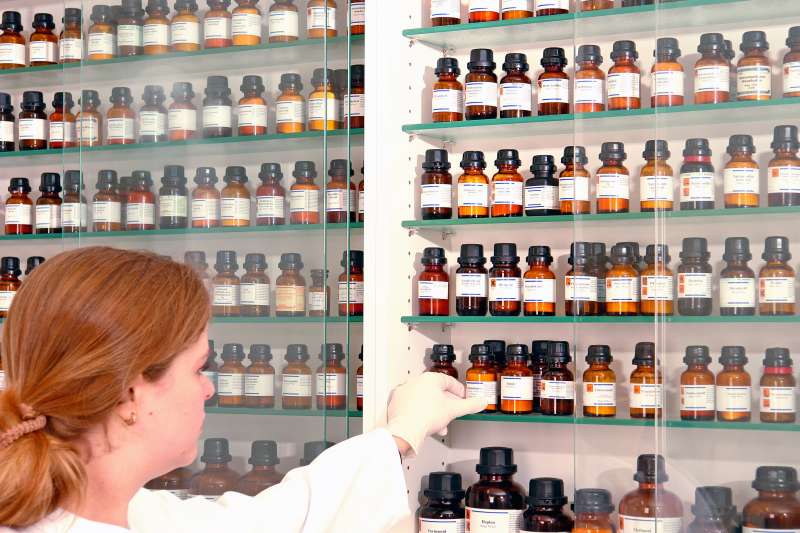 pharmacist pulling bottles off the shelves of apothecary