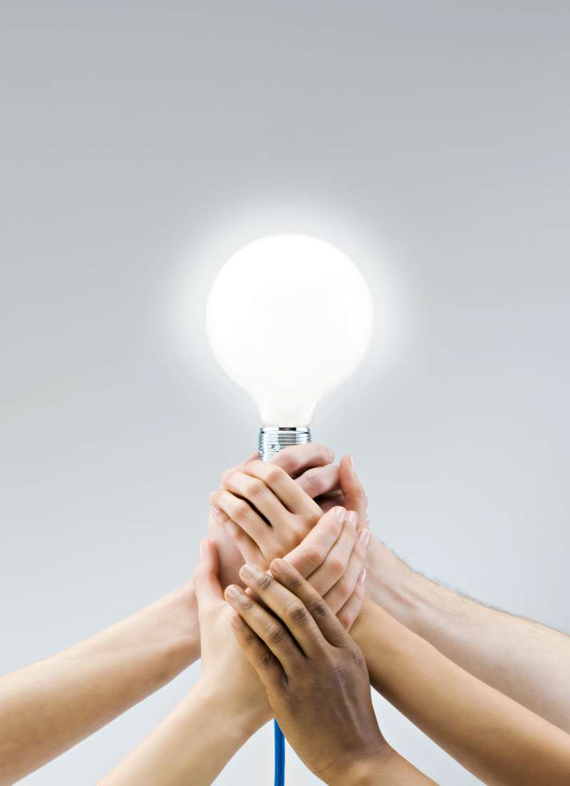 multiple hands holding lightbulb