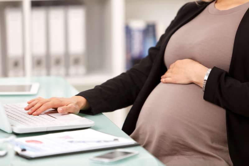 closeup of pregnant woman at office desk