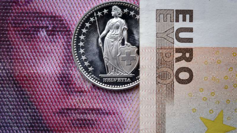 A Swiss coin is seen beneath a euro banknote on Januay 15, 2015 in Lausanne. In a shock announcement on January 15, Switzerland's central bank said it was ending a three-year bid to artificially hold down the value of the Swiss franc against the euro, in a move that immediately sent the safe haven currency soaring.