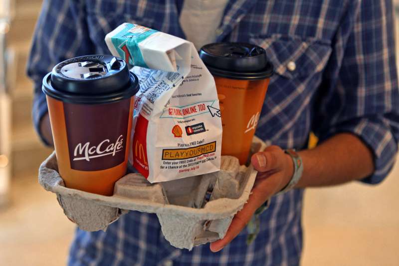 A customer carries McCafe cups and a bag of food