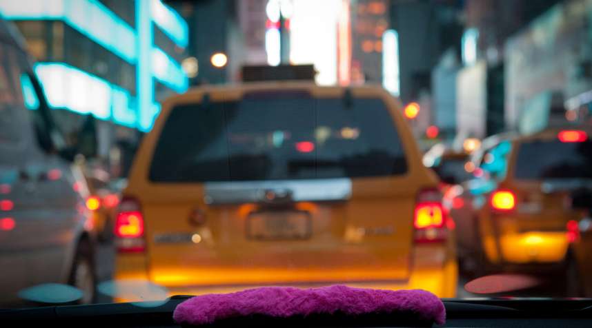 A pink mustache on the dashboard as Bouchaib El Hassani, 31, a Lyft driver, makes his way through midtown.