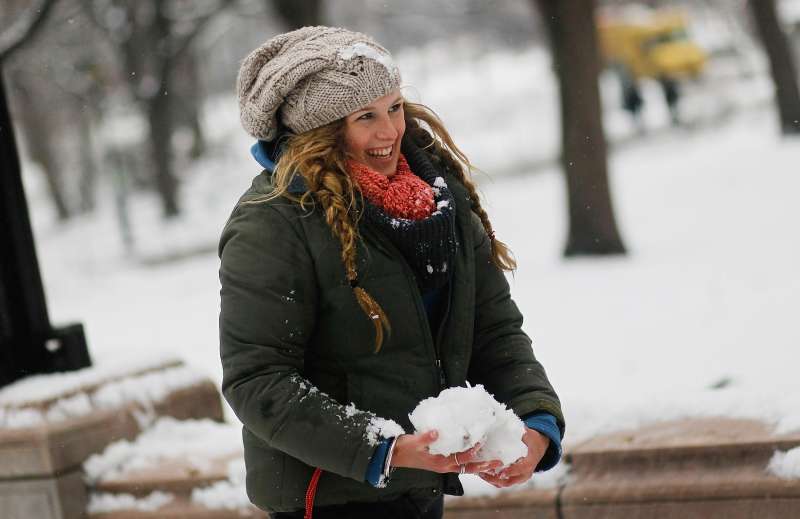 A woman gathers snow for a friendly snowball fight in Central Park.