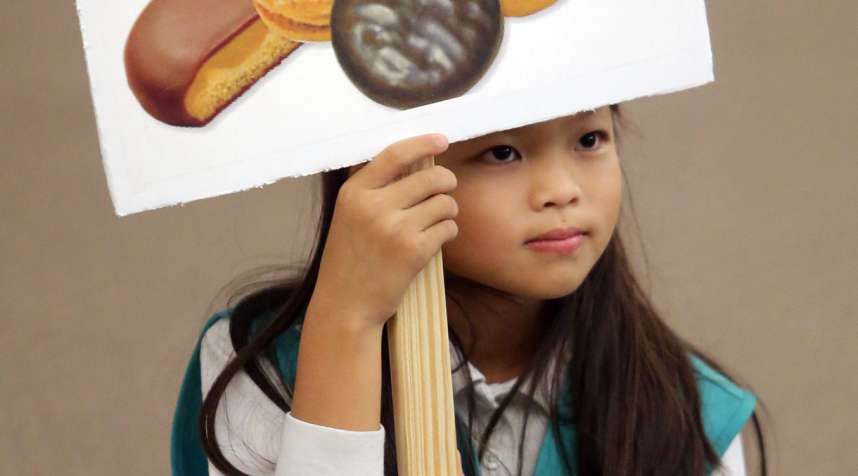 Ashley Rubin, 9, holds a sign during Girl Scout Troop 582's cookie training session at Beach Vineyard Church in Panama City Beach, Florida, 2015.