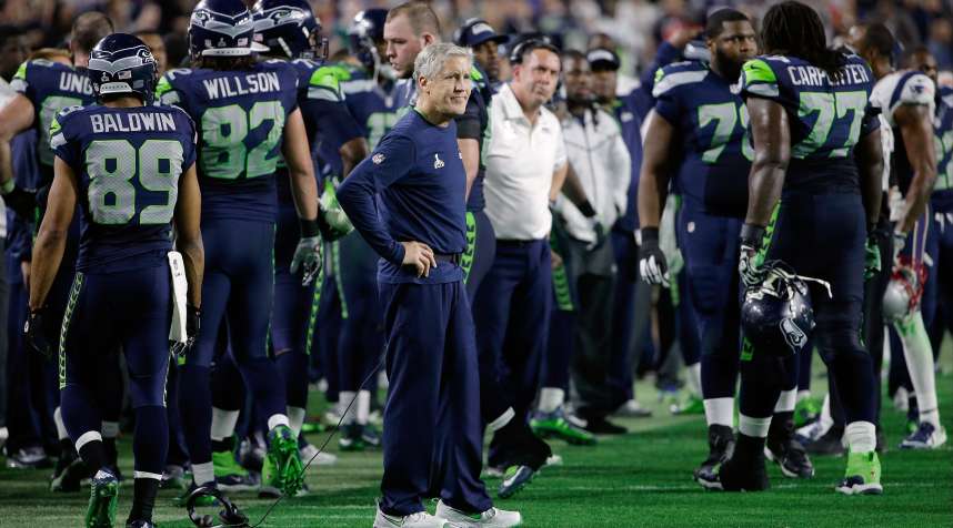 Seattle Seahawks head coach Pete Carroll, center, watches as players react after Russell Wilson was intercepted by New England Patriots strong safety Malcolm Butler during the second half of NFL Super Bowl XLIX.