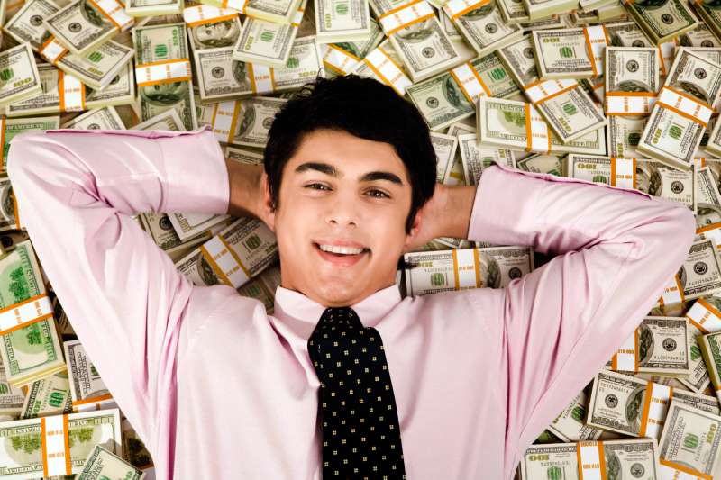 businessman laying on field of money