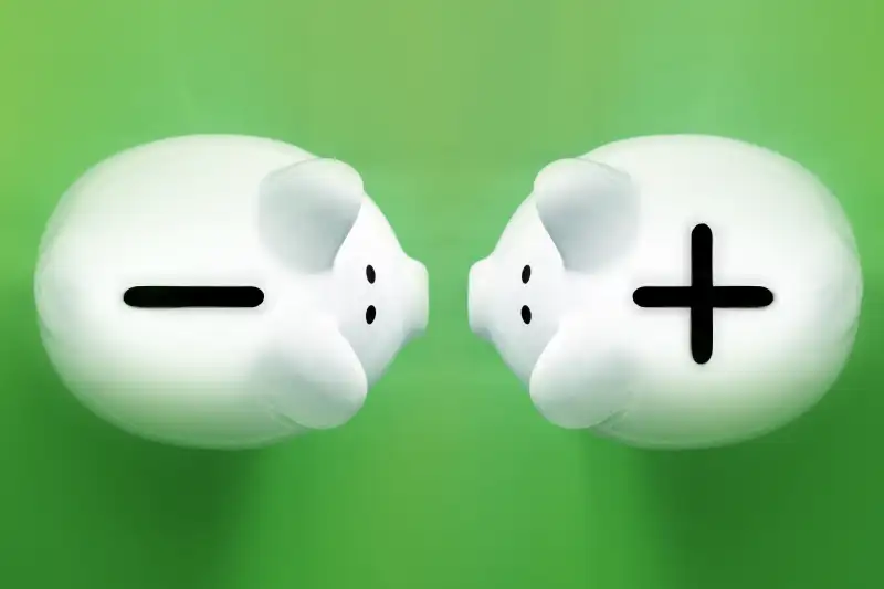 piggy banks shot in an aerial view with + and - slots on top of them