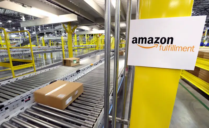 A package moves along a conveyer belt, at a new Amazon.com fulfillment center in DuPont, Wash. The center is one of 50 around the country and three in the Puget Sound area that process and ship Amazon customer orders using a mix of robotic technology and human employees.