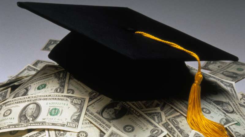 mortarboard on top of pile of cash
