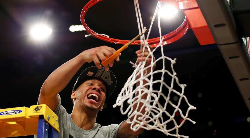 Shabazz Napier #13 of the Connecticut Huskies cuts down the net after defeating the Michigan State Spartans to win the East Regional Final of the 2014 NCAA Men's Basketball Tournament at Madison Square Garden on March 30, 2014 in New York City.