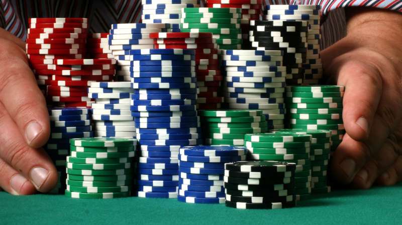 hands pushing poker chip stacks on table