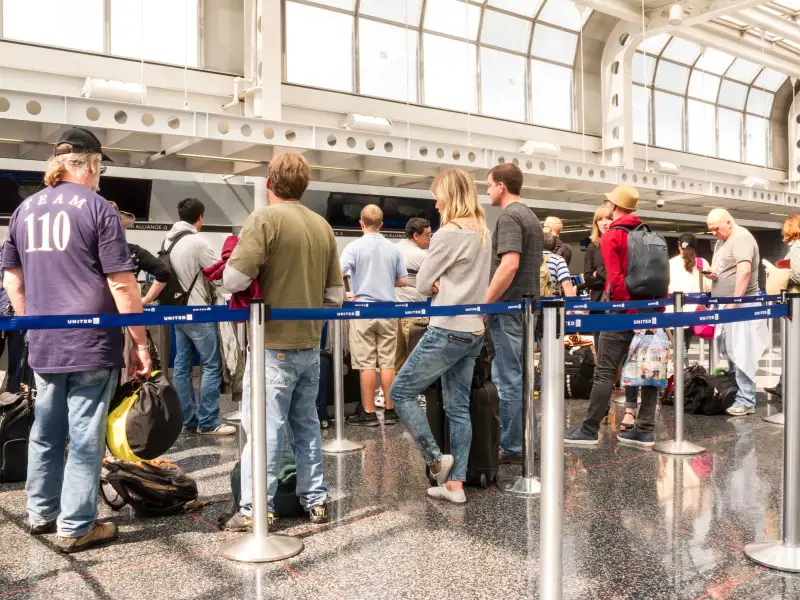customers waiting in line at airport check-in counter