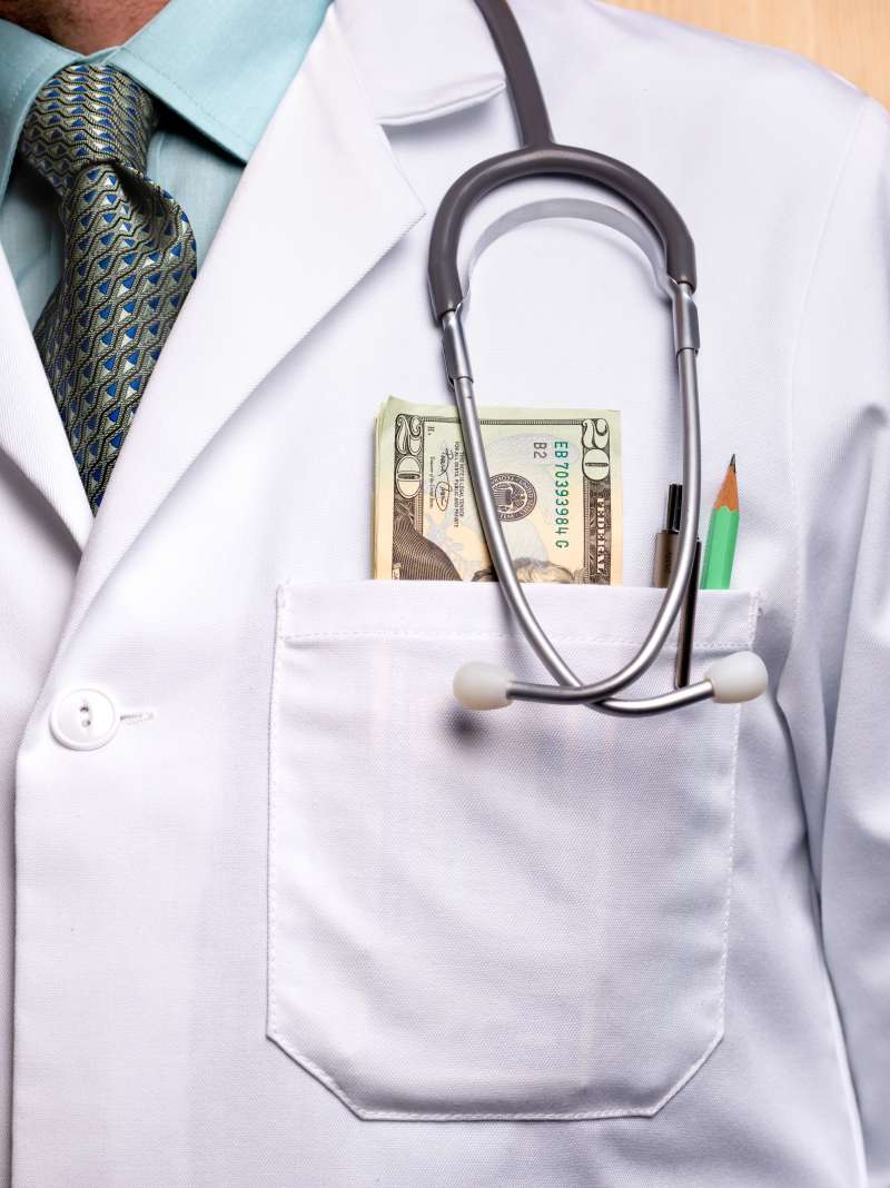 doctor with money in his lab coat pocket