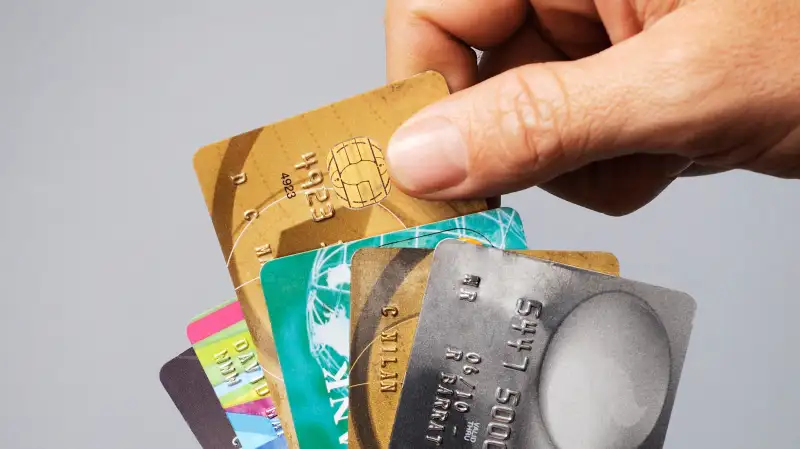 hand choosing credit cards from a fan of cards