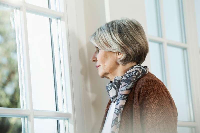 senior woman staring out window