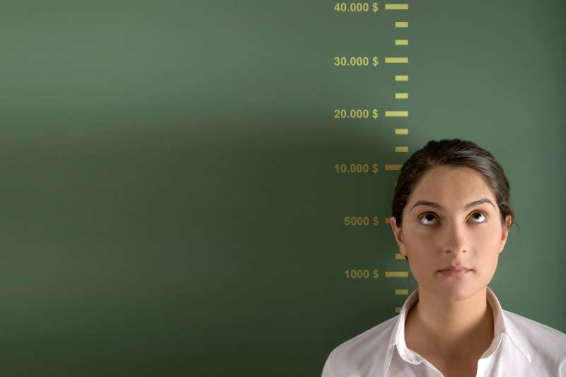 new grad in front of height chart that measures salary