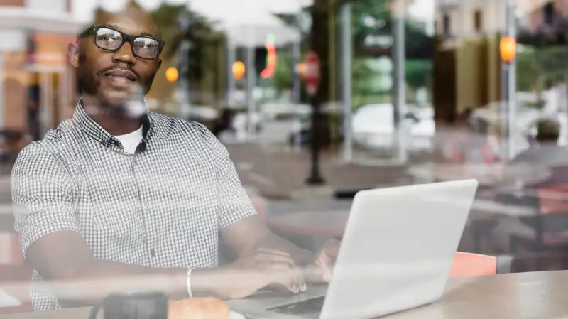 man using laptop in coffee shop