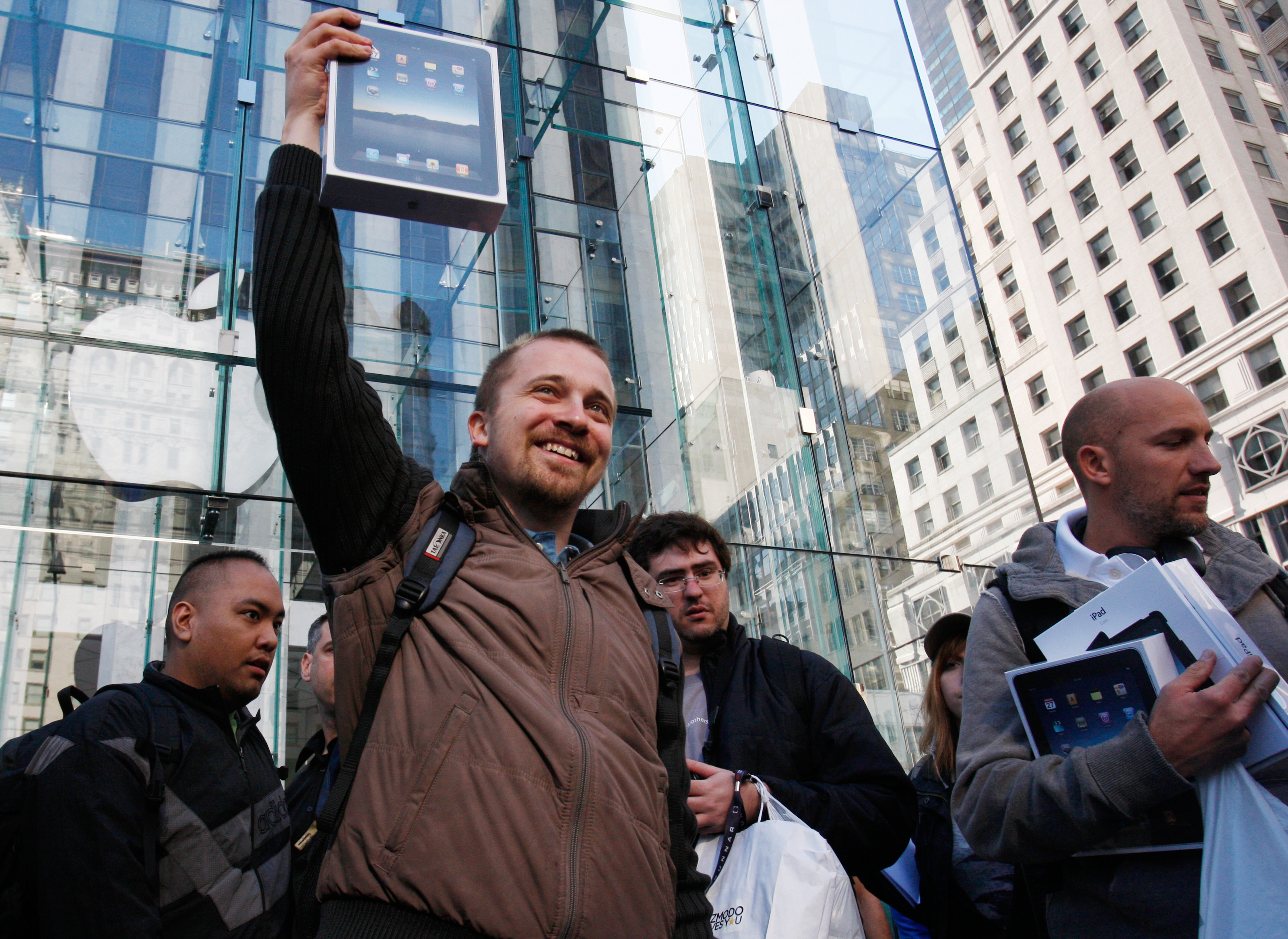 A customer lifts his iPad over his head after leaving the iPad launch at the Apple Store in New York.