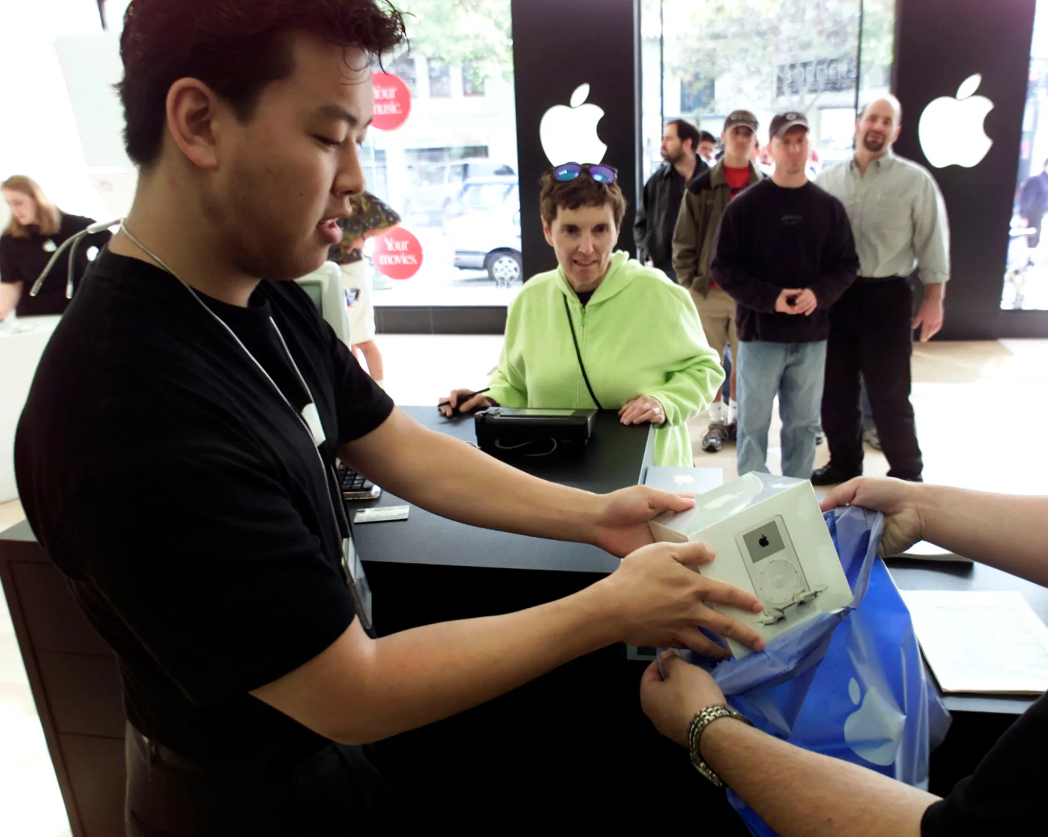 A salesperson bags a new Apple iPod MP3 player shortly after the Apple store opened in Palo Alto, California, November 10, 2001. Apple stores across the country hosted lines of eager customers wanting to be among the first to own iPod. The breakthrough MP3 player holds up to 1,000 songs and fits in your pocket.