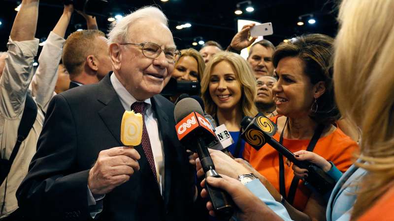 Berkshire Hathaway CEO Warren Buffett talks to reporters while holding an ice cream at a trade show during the company's annual meeting in Omaha, Nebraska May 3, 2014. Warren Buffett's Berkshire Hathaway Inc on Friday said quarterly profit declined 4 percent, falling short of analyst forecasts, as earnings from insurance underwriting declined and bad weather disrupted shipping at its BNSF Railway unit.