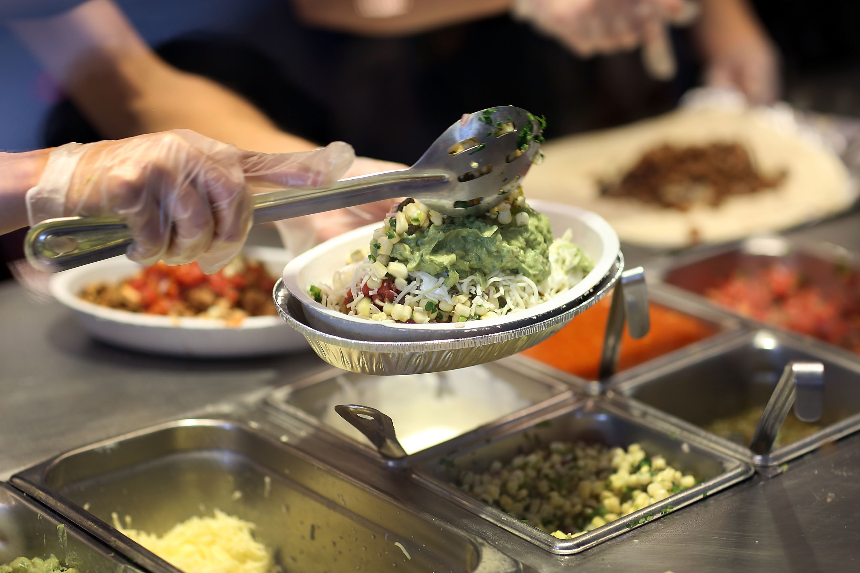 Chipotle restaurant workers fill orders for customers on the day that the company announced it will only use non-GMO ingredients in its food on April 27, 2015 in Miami, Florida. The company announced, that the Denver-based chain would not use the GMO's, which is an organism whose genome has been altered via genetic engineering in the food served at Chipotle Mexican Grills.