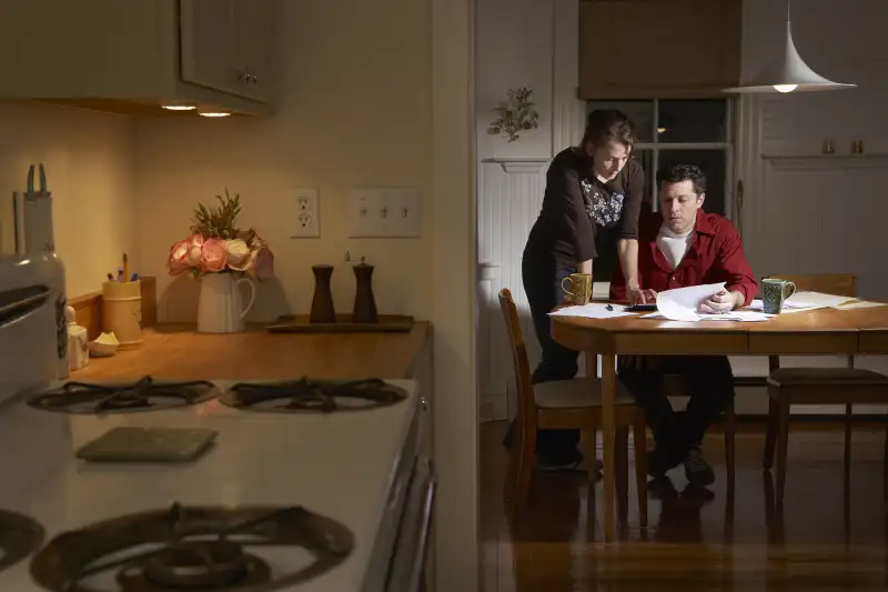 couple paying bills in kitchen