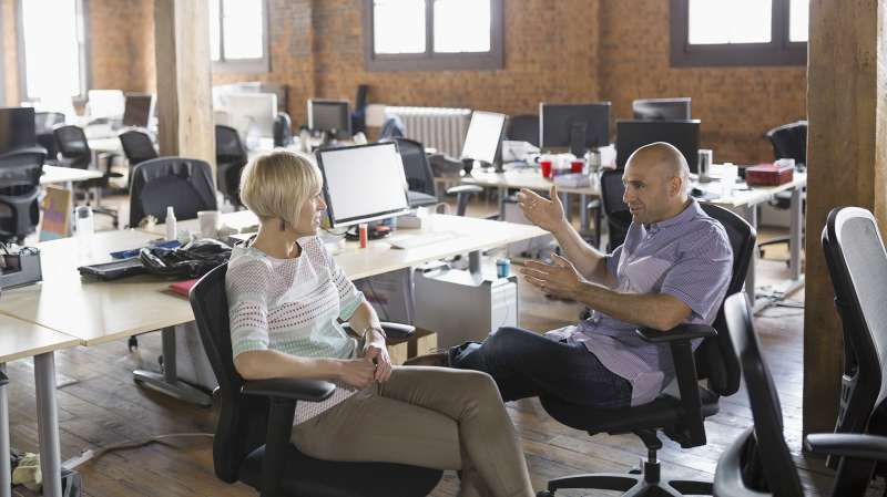 man and woman in startup company having conversation