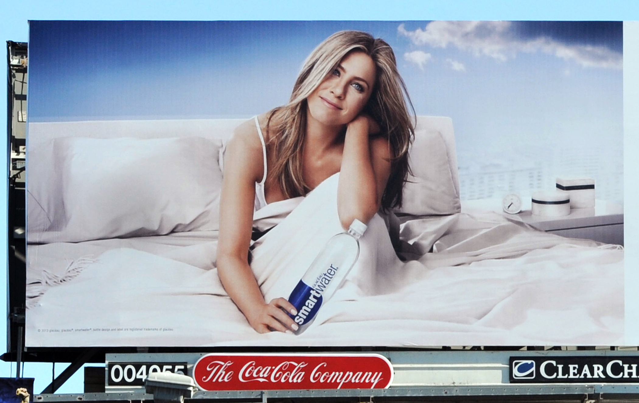 Jennifer Aniston stars in her new 'Smartwater' advert in Los Angeles. The 44 year old is pictured sitting in bed holding on to a 'smartwater' bottle. The new billboard campaign reads 'inspired by the clouds'.
