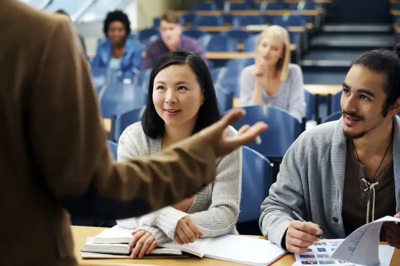 college students listening to professor in lecture hall