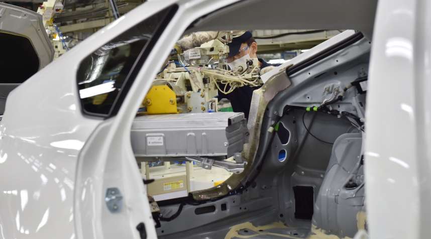 An employee fixes a main battery of the hybrid system in Toyota Motor's Prius.