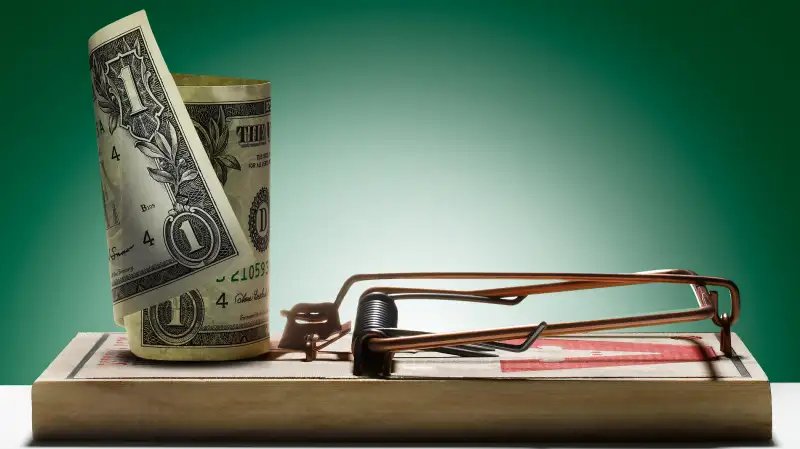 rolled up dollar in a mousetrap