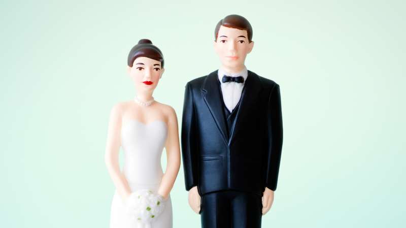 wife and groom figurines on piles of change