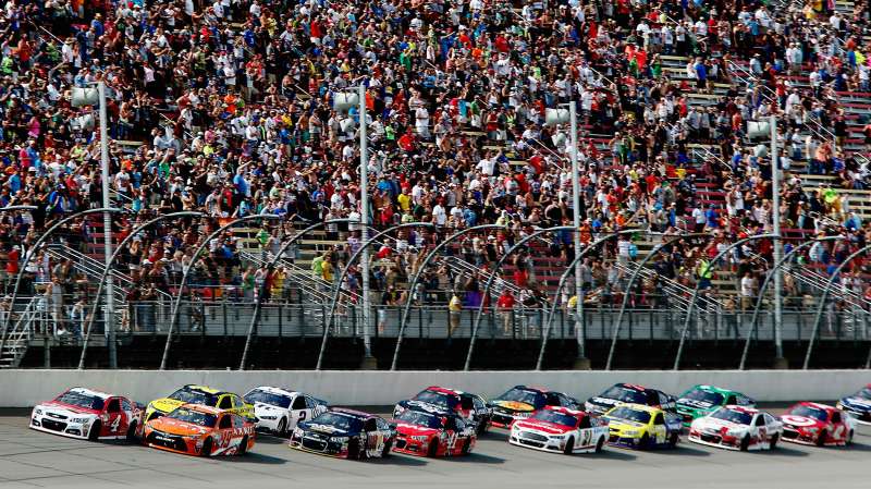 Carl Edwards, driver of the #19 ARRIS Toyota, and Kevin Harvick, driver of the #4 Budweiser/Jimmy John's Chevrolet, lead the field to a restart during the NASCAR Sprint Cup Series Quicken Loans 400 at Michigan International Speedway on June 14, 2015 in Brooklyn, Michigan.