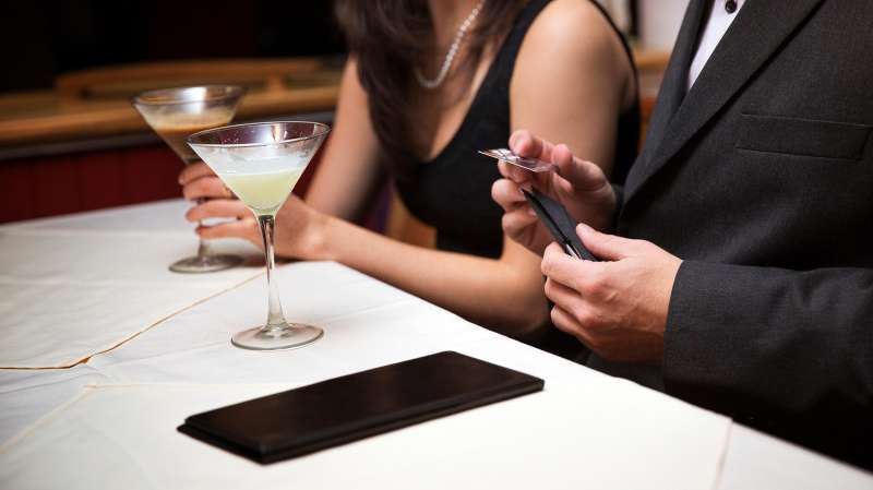 couple on first date, man paying with credit card