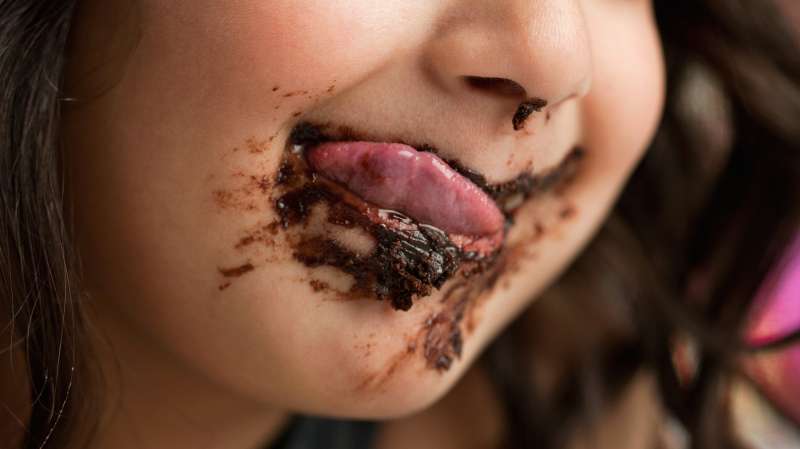 girl with licking chocolate off her face