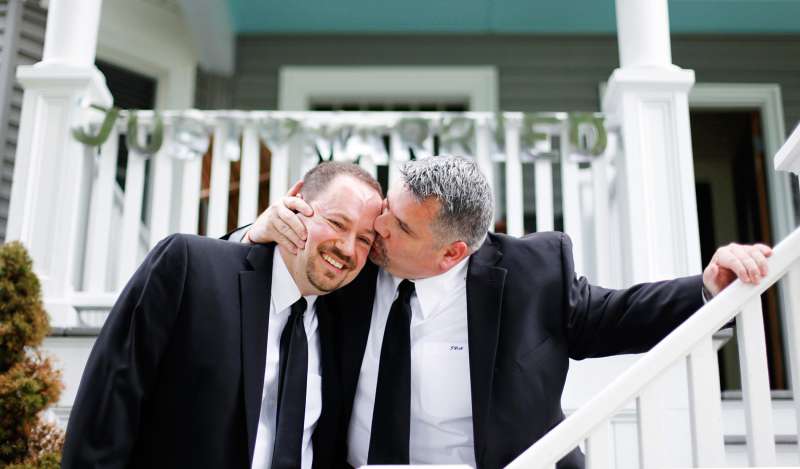 Jay Norris gives his partner, Doug Fillmore, a kiss under a Just Married sign their neighhbors put up for them at their home on the Eastern Promenade in Portland. The couple was married in a small ceremony at Cathedral Church of St. Luke in Portland. Jay and Doug moved to Maine specifically in order to be married and begin a new life together.