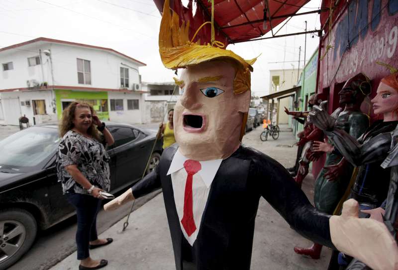 A Mexican client who lives in the U.S., looks at a pinata depicting U.S. Republican presidential candidate Donald Trump hanging outside a workshop in Reynosa, Mexico, June 23, 2015. Days after billionaire Trump accused Mexico of sending criminals to live in the United States, a Mexican artisan has given angry Mexicans an outlet-- a Trump pinata they can stuff with candy and beat with a stick. In the Mexican border city of Reynosa, Dalton Ramirez works at his family's pinata shop where they create a variety of paper mache figures to be filled with treats and broken open with sticks on birthdays and holidays.