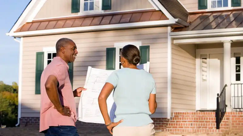 couple standing outside house