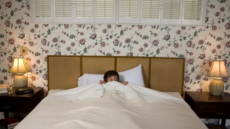 Man in bed with scared look