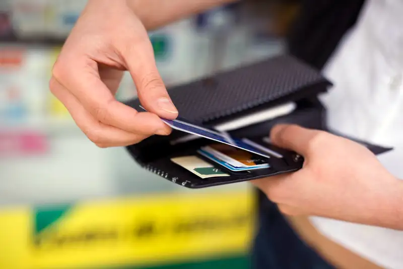 person pulling credit card from wallet