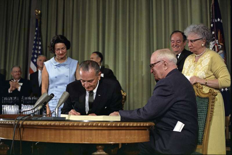 President Lyndon Johnson signing Medicare Bill in Independence, Missouri while Harry Truman looks on, July 30, 1965.