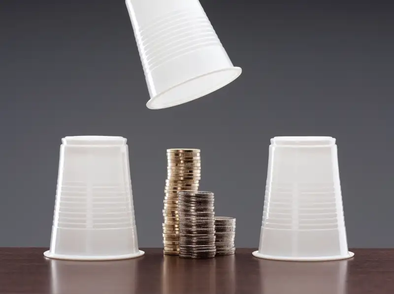 cup game with one cup revealing stacks of coins