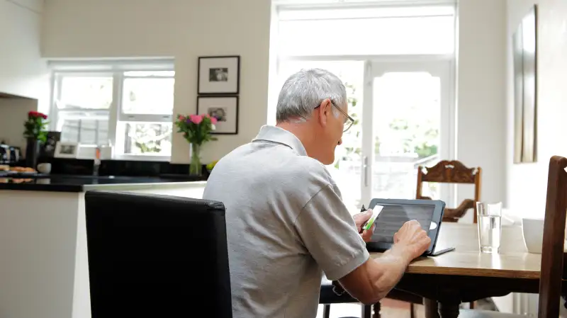 senior mature man on laptop in kitchen