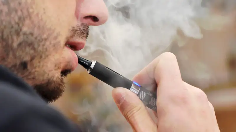 man smoking e-cigarette vaping