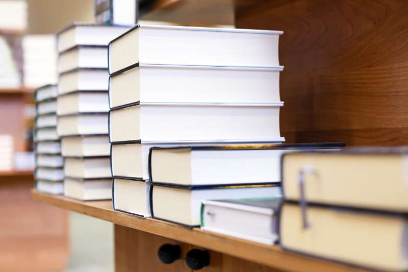 stacks of textbooks on shelves