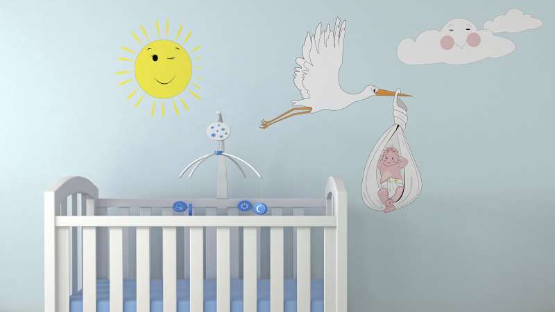 nursery with decal of stork carrying baby on wall
