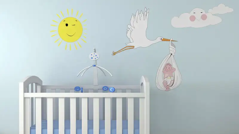 nursery with decal of stork carrying baby on wall